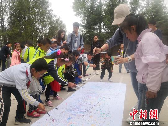 图为山区孩子们和城里孩子们共同完成画作。　崔琳 摄