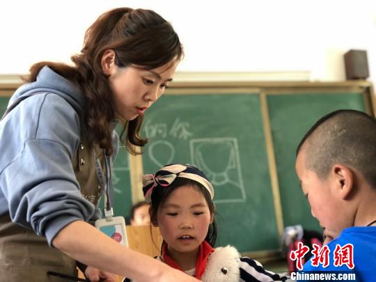 图为城市爱心机构教师给孩子们指导画作。　崔琳 摄