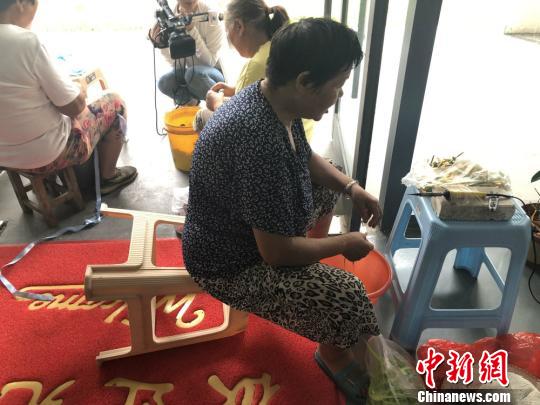 当地低收入群众在饰品电商产业园内做饰品加工活。　于从文 摄